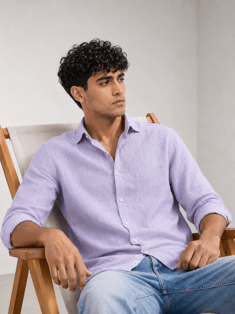 Model wearing lavender linen shirt in seated pose